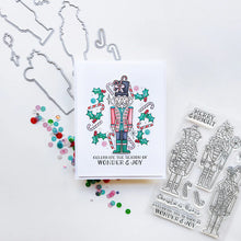 Load image into Gallery viewer, Catherine Pooler - Stamp & Die Set - Nutcracker Sweet. Meet the cutest nutcrackers in town! This whimsical set features charming nutcrackers adorned in a delightful array of sweets and treats, including cupcakes, candy canes, and figgy pudding. Available at Embellish Away located in Bowmanville Ontario Canada. Example by Catherine Pooler Designs.