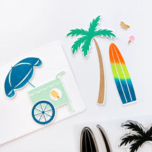 Load image into Gallery viewer, Catherine Pooler - Stamp & Die Set - On the Boardwalk. This set is perfect for building scenes, clustering or simple cards. This set includes a palm tree, surf board, the boardwalk fence and all the bits to build your own treat cart. Available at Embellish Away located in Bowmanville Ontario Canada.