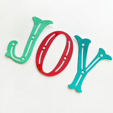 Load image into Gallery viewer, Catherine Pooler - Word Die - Festive Joy. Celebrate the season with the Festive Joy Word Die! This beautiful large "JOY" die can serve as the focal point of your holiday cards, adding a bold and cheerful touch. Available at Embellish Away located in Bowmanville Ontario Canada.
