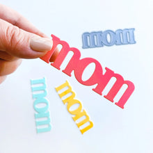 Cargar imagen en el visor de la galería, Catherine Pooler - Word Die - Just Mom. Send a card to your favorite mom! The Just Mom Word Die is a simple block font "mom" that will be a cute addition to any card for mother's day or any day celebrating your best lady! Take the "m" and cut one hump off to create "mum"! The Mom Word Die measures approx. 3" x 1". Illustrated by Lisa Kirkbride. Available at Embellish Away located in Bowmanville Ontario Canada.