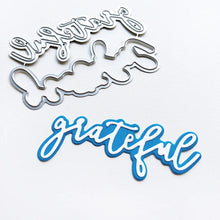 Cargar imagen en el visor de la galería, Catherine Pooler - Layered Word Dies - Grateful. This two-piece die give you multiple options for using the die alone or with a background layer. Add your favorite embossing powder or medium for extra sparkle and shine. Available at Embellish Away located in Bowmanville Ontario Canada.
