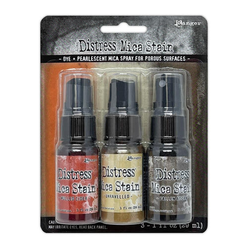 Tim Holtz - Distress Mica Stain Set - Halloween Set #5. Tim Holtz Distress Mica Stains are a colorful elixir of pearlescent shimmer for mixed media and papercraft projects. This set includes colors Mulled Cider, Unravelled and Fallen Acorn. Available at Embellish Away located in Bowmanville Ontario Canada.