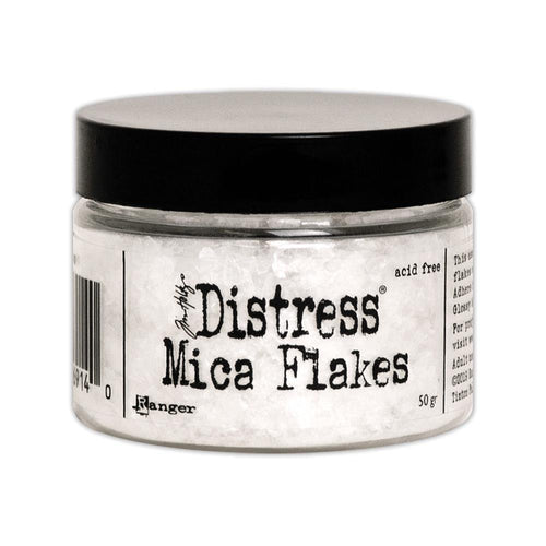Tim Holtz - Distress Mica Flakes - 50g. This assortment of various sized translucent mica flakes will add an old-fashioned subtle sparkle. Adhere flakes with Distress Collage Medium, Ranger Glossy Accents, or other adhesives (sold separately). This package contains 50g of mica flakes. Conforms to ASTM D 4236. Imported. Available at Embellish Away located in Bowmanville Ontario Canada.