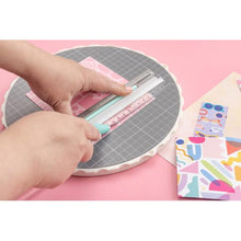 Charger l&#39;image dans la galerie, We R Memory Keepers - Rotating Platform &amp; Cutting Mat 10&quot;. Work on your projects from every angle with the Rotating Cutting Mat. This unique cutting mat features a removable, replaceable, self-healing mat that you can turn instead of your projects. Available at Embellish Away located in Bowmanville Ontario Canada.
